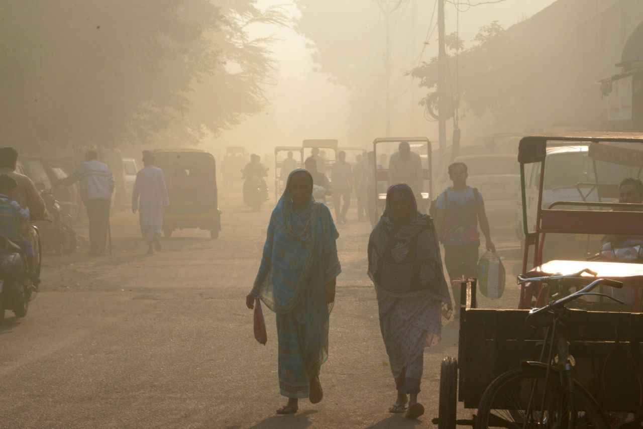 Indian commuters walk through the smog in the old quarters of New Delhi.
