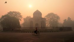 TOPSHOT - An Indian cyclist rides along a street as smog envelops a monument in New Delhi on October 31, 2016, the day after the Diwali festival.
New Delhi was shrouded in a thick blanket of toxic smog a day after millions of Indians lit firecrackers to mark the Diwali festival, causing the air pollution to hit "severe" level. The pollutants breached the 1000 microgram mark in the Indian capital and shot up nearly 10 times above the normal level in  the early hours of Monday, mostly owing to bursting of millions of firecrackers, according to a weather scientist.
 / AFP / MONEY SHARMA        (Photo credit should read MONEY SHARMA/AFP/Getty Images)