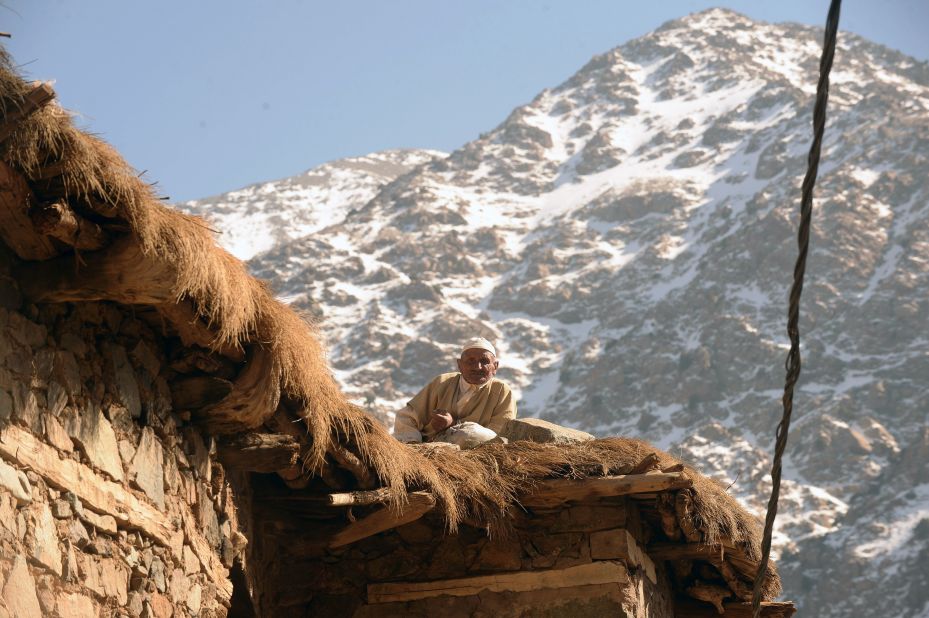 A Moroccan man sits on the roof of his house. Ski tours often stay in refuges in the mountains; basic shelters with bunk beds and maybe a hearth from where parties can explore each day.