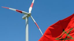 A Moroccan flag flies next to a wind turbine on June 28, 2010 at a 250-million-euro (300 million US dollar) wind farm near Tangiers shortly after its inauguration by Moroccan King Mohammed VI. The farm in Melloussa, 34 kms (21 miles) from Tangiers in northern Morocco, has 165 turbines, with a production capacity of 140 megawatts. The project was part-financed by the European Bank, which invested 80 million euros, while Spanish and German banks put in a total of 150 million euros.  AFP PHOTO / ABDELHAK SENNA (Photo credit should read ABDELHAK SENNA/AFP/Getty Images)