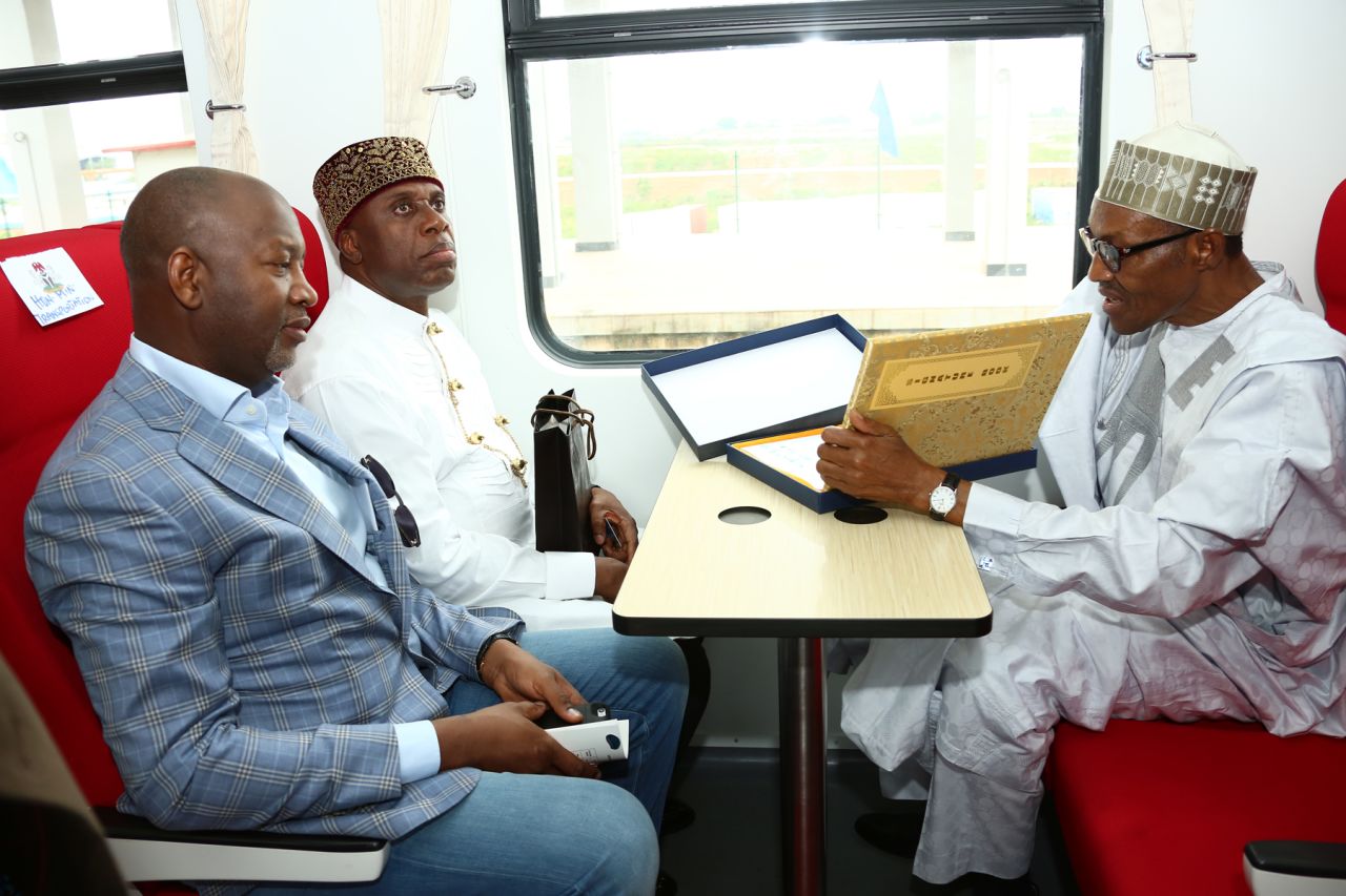 Nigerian President Mohammadu Buhari (right) signs visitor's register during an opening ceremony in July 2016. China Exim bank loaned $500 million toward the railway, which cost a total of $874 million, according to SAIS.