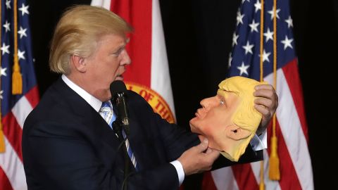 Trump checks out a rubber mask of himself during a campaign rally in Sarasota, Florida, on November 7.