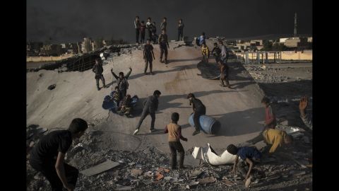 Children play in debris created by an airstrike in Qayyara on Sunday, November 6.