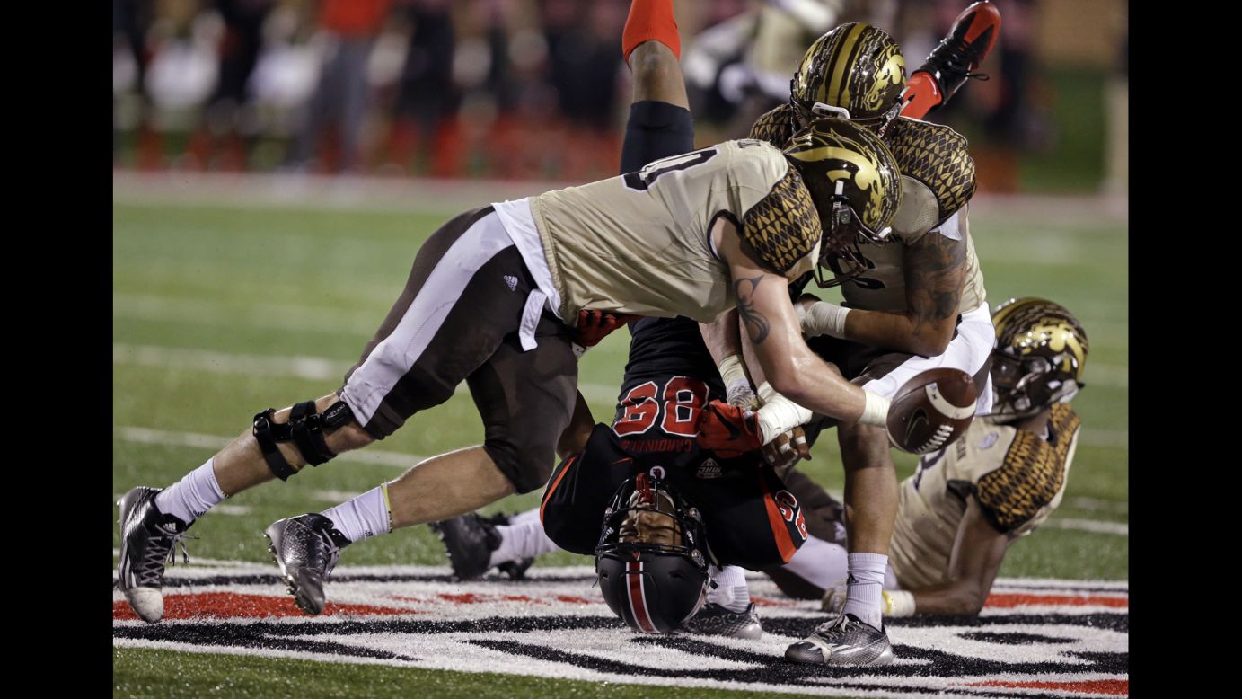 Ball State wide receiver Damon Hazelton Jr. fumbles the ball as he's hit by Western Michigan players in Muncie, Indiana, on Tuesday, November 1.