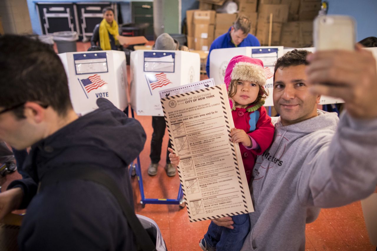 A man snaps a selfie with his child as he waits to vote in Brooklyn, New York.