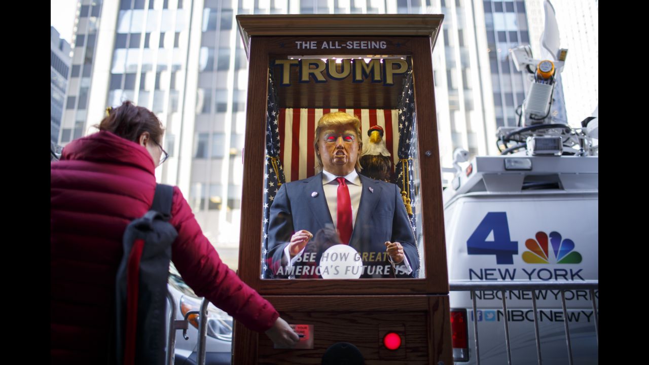 A tourist takes her "misfortune" slip from The All-Seeing Trump, a machine set up across the street from the New York Hilton Midtown Manhattan Hotel.