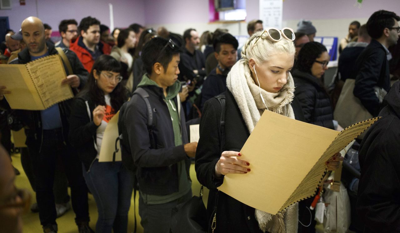 A woman reads over a ballot while waiting to vote in Brooklyn.