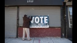 A man hangs a sign reminding people to vote in Philadelphia, Pennsylvania.