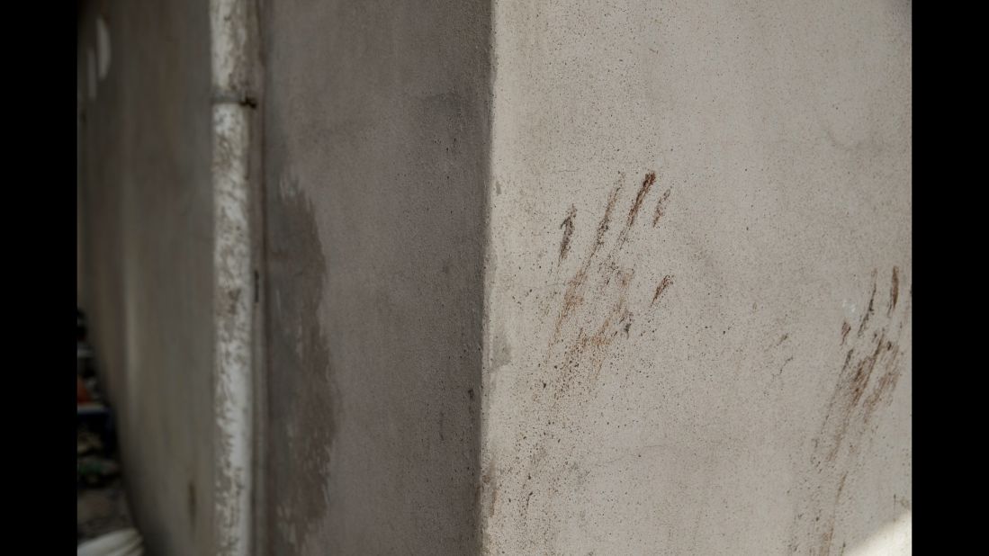 Handprints are seen on a wall.
