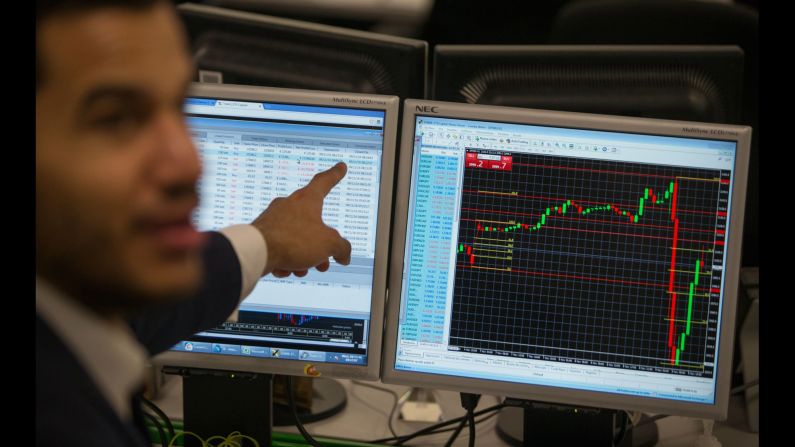 A stock trader at ETX Capital in London gestures to a screen showing the S&P 500 Index on November 9. <a href="index.php?page=&url=http%3A%2F%2Fmoney.cnn.com%2F2016%2F11%2F08%2Finvesting%2Fglobal-markets-stocks-trump-clinton-us-presidential-election%2F" target="_blank">Global stock markets dropped</a> as Trump's victory became more likely on Election Day.