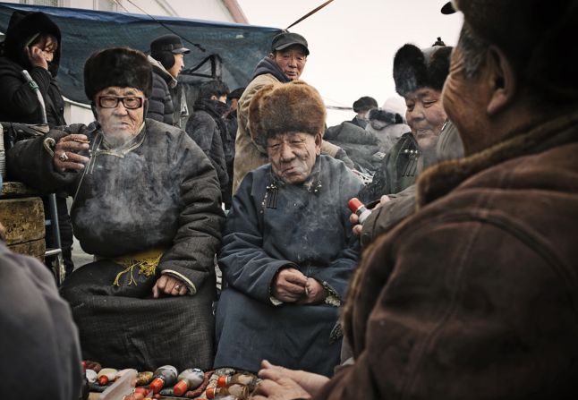 "Locals smoke cigars in an Ulaanbaatar market."