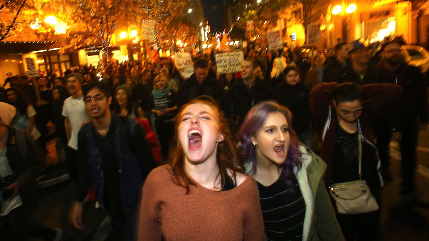 Sasha Savenko, left, and Sydney Kane join thousands of protesters in Seattle on November 9.