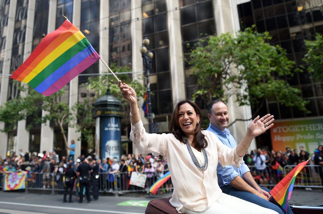 Kamala Harris waves a rainbow flag while participating in the San Francisco Pride parade in June.