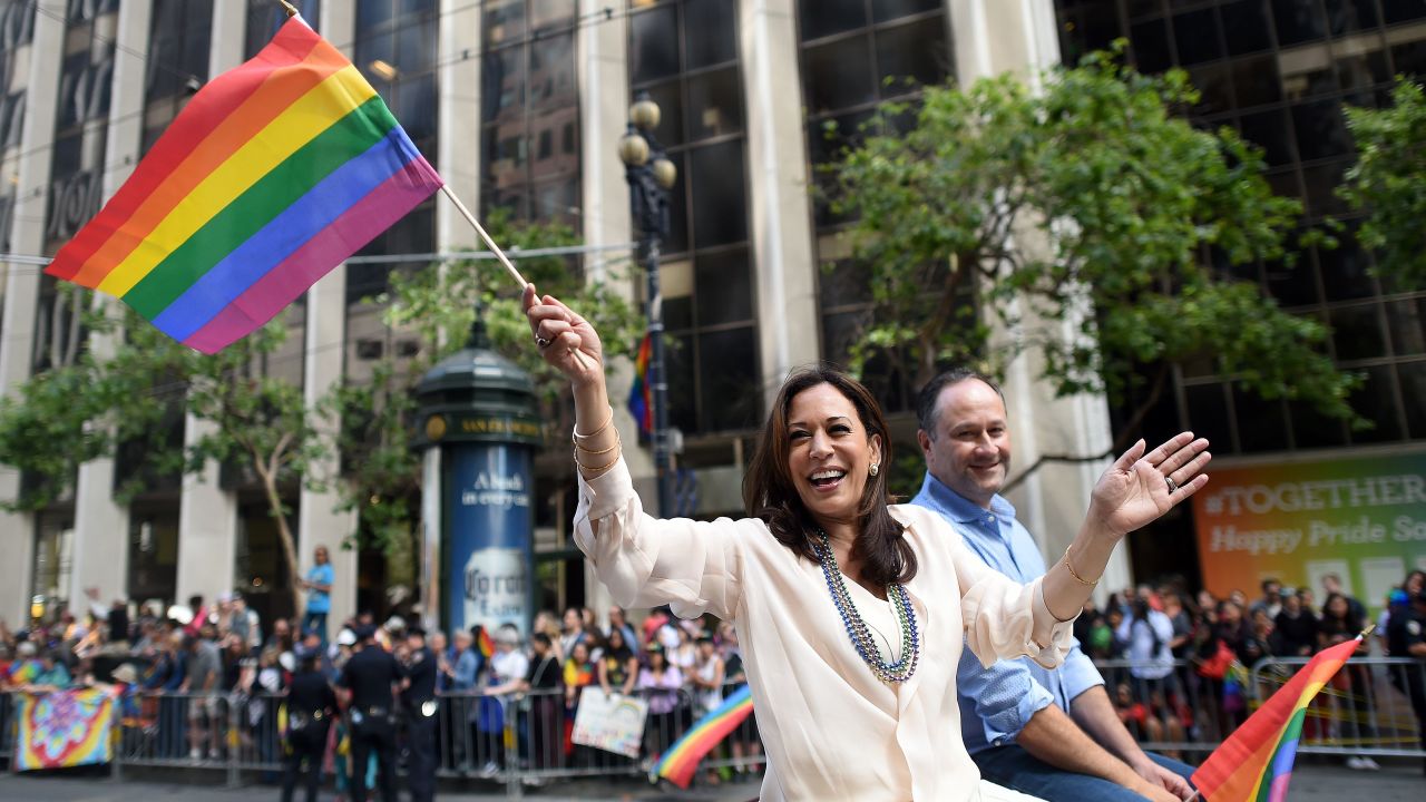 Kamala Harris waves a rainbow flag while participating in the San Francisco Pride parade in June.