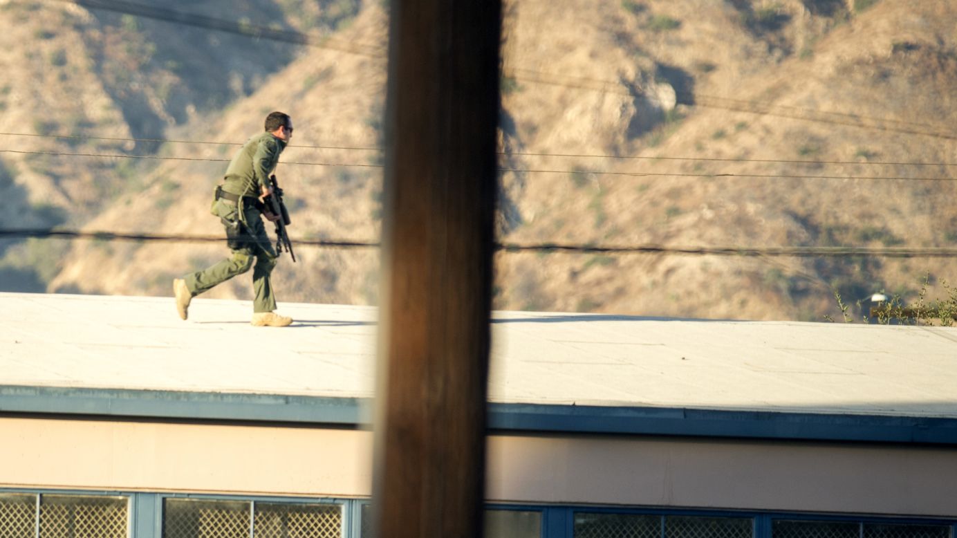 A SWAT team sniper moves atop a building to cover a barricaded suspect in Azusa, California, on Tuesday, November 8. One person was killed and two were injured after a man opened fire near a Southern California polling station. The suspected shooter had been "bingeing on cocaine," <a href="http://www.cnn.com/2016/11/08/politics/la-area-polling-station-on-lockdown-after-shots-nearby-at-least-two-victims/" target="_blank">police said</a>.