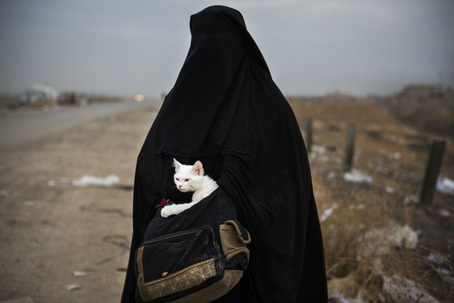 An Iraqi woman displaced by war holds her cat near a checkpoint in the Iraqi village of Shaqouli, east of Mosul, on November 10.