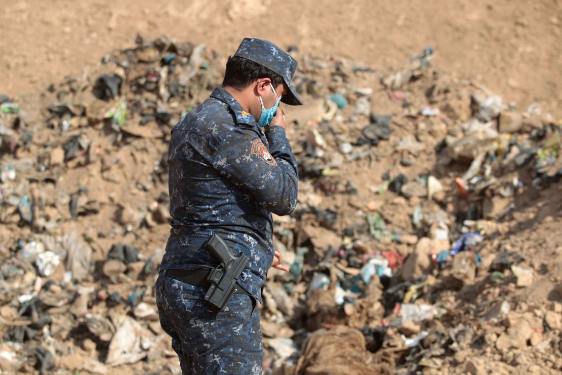 An Iraqi soldier checks a mass grave in Hamam al-Alil, an area recently retaken from ISIS.