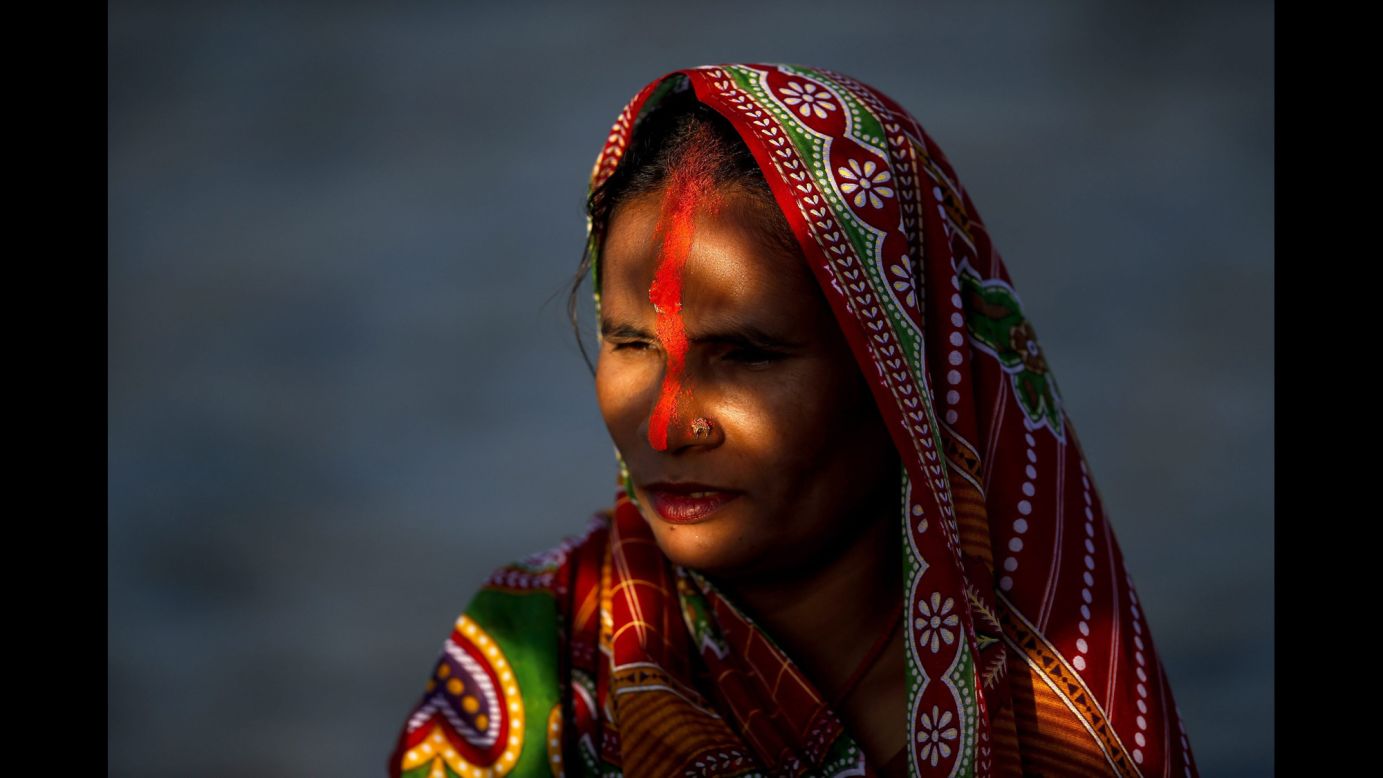 A Nepalese woman prays to the setting sun while standing in the Bagmati River during the Chhath Puja festival in Kathmandu, Nepal, on Sunday, November 6. Chhath Puja is celebrated in honor of the Hindu sun God Surya, and sees people come together to worship for a peaceful and prosperous life and good will. 
