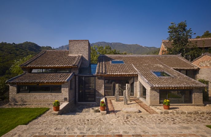 Stone Forest was originally an abandoned three-room hut. It has since been transformed into a romantic getaway complete with an outdoor shower, private courtyard, stained glass panels, and an outdoor terrace with views of the Great Wall.