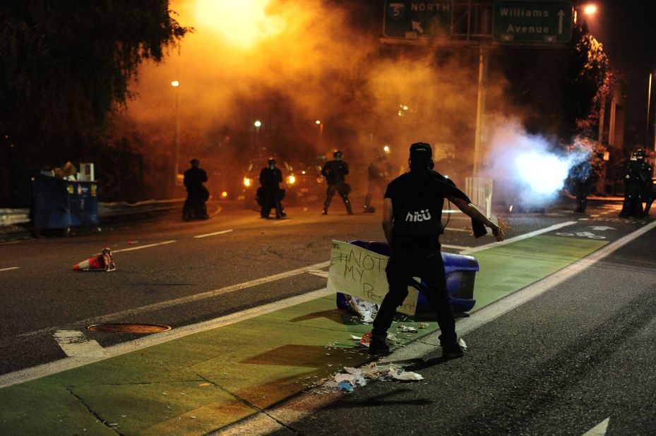 Police officers look on as someone protests in Portland on November 10.