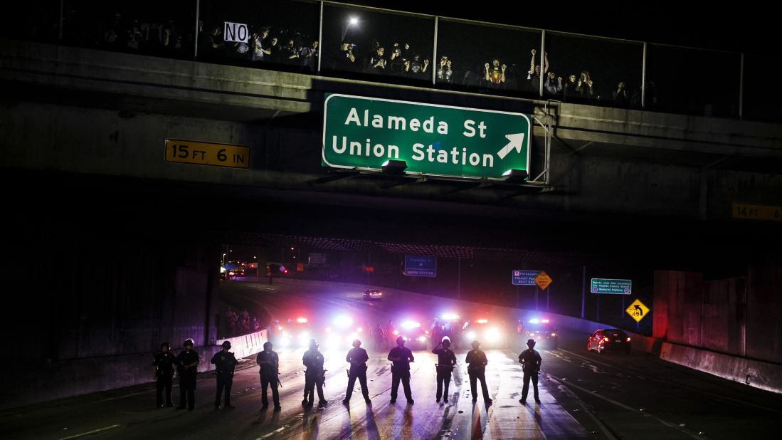 Police officers stand guard as they slowly clear Trump protesters from the 101 Freeway in Los Angeles on November 10.