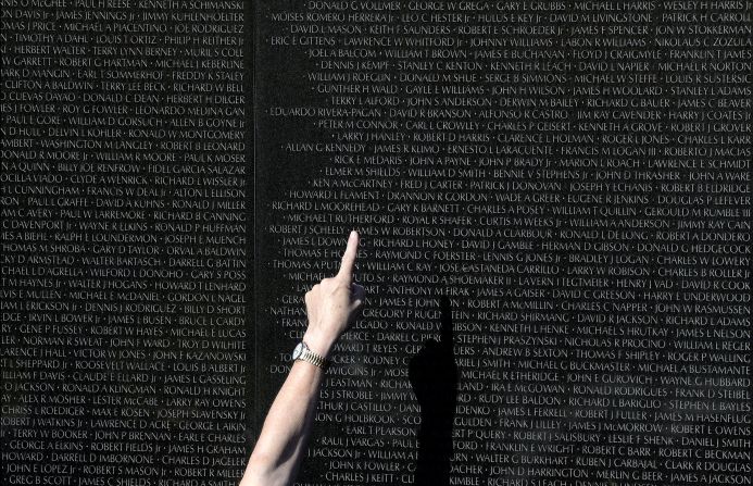 A Park Service volunteer in Washington points to a name on the Vietnam Veterans Memorial on November 11.
