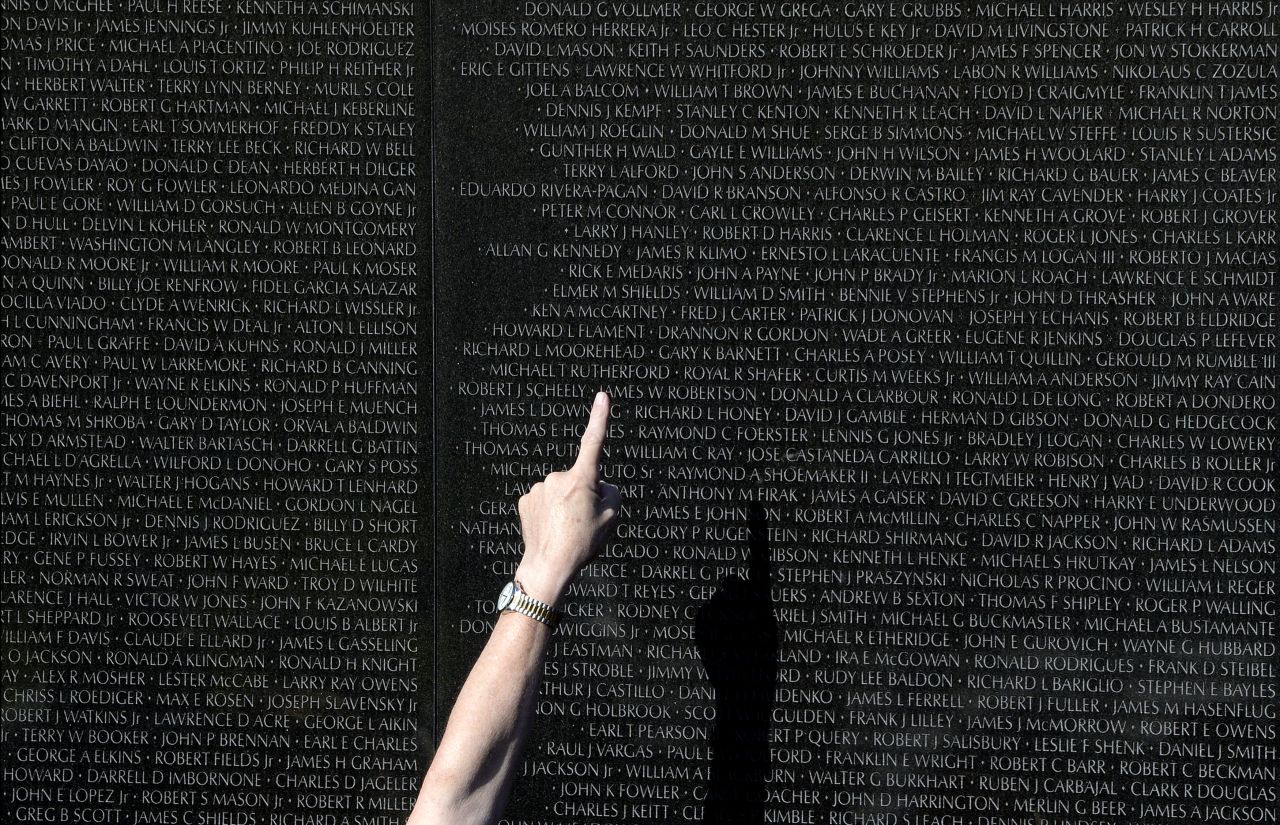 A Park Service volunteer in Washington points to a name on the Vietnam Veterans Memorial on November 11.