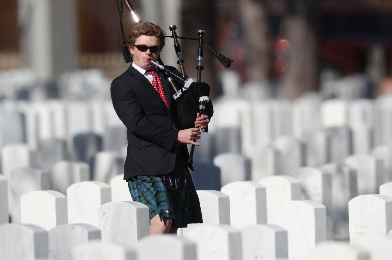 Sixteen-year-old Colin Lewis of Denver plays the bagpipes as he walks amid the headstones of veterans and their family members to mark Veterans Day in Fort Logan National Cemetery on November 11 in Sheridan, Colorado. 