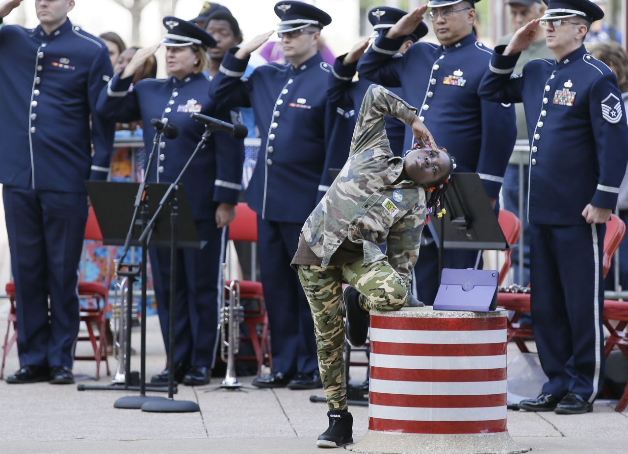 Keyleighia Harrler, 8, salutes with service members during a Veteran's Day celebration in Dallas on November 11. 