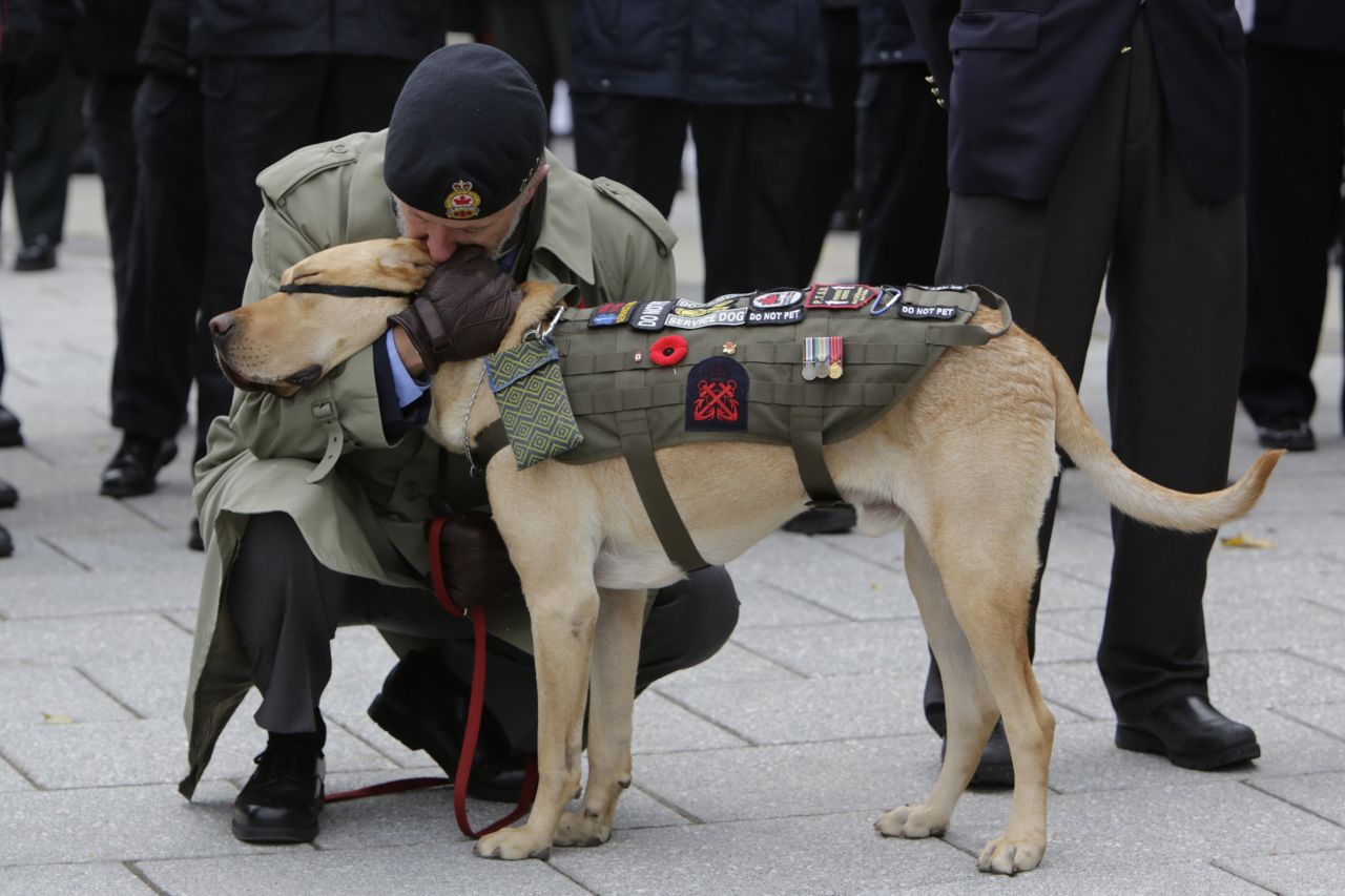 A veteran kisses his service dog during Remembrance Day ceremonies at the National War Memorial in Ottawa, Ontario, on November 11.