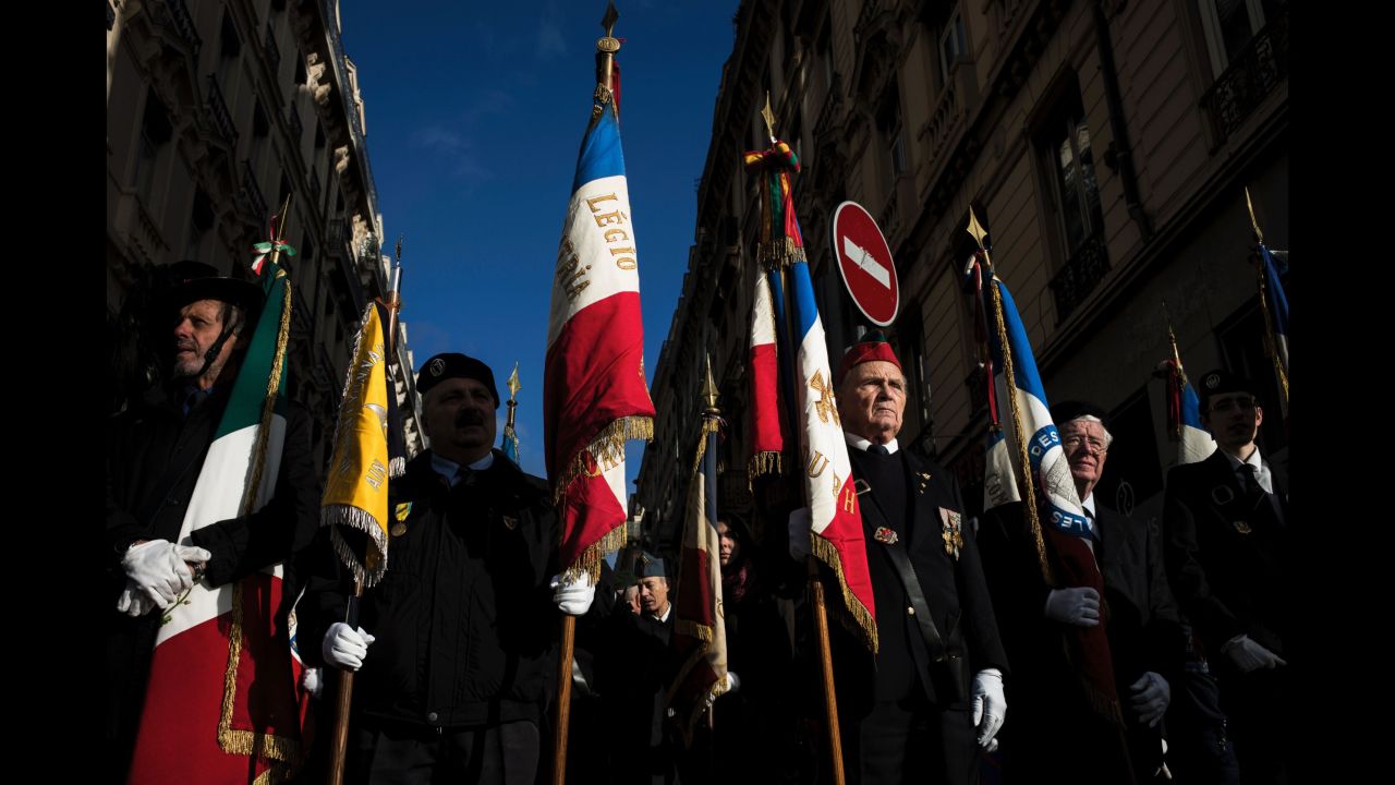French veterans hold flags Friday, in a street of Lyon, France during the Armistice Day ceremony marking the 98th anniversary of the end of World War I. 