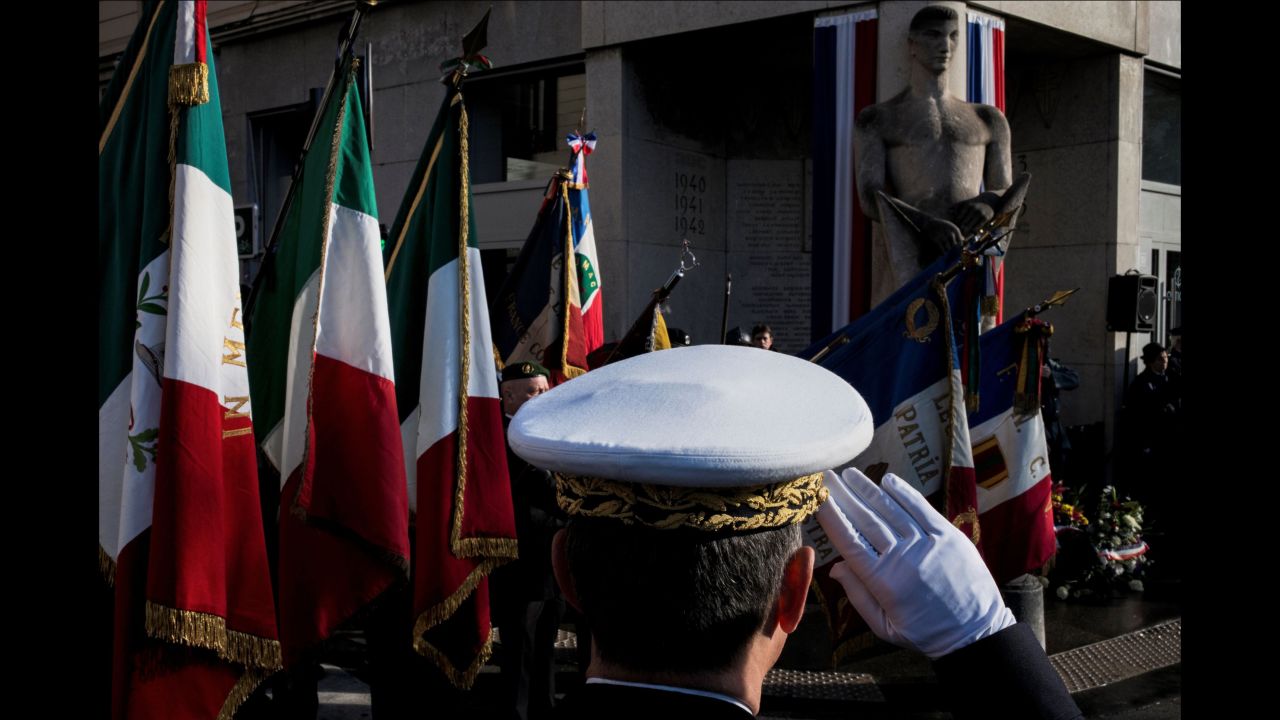 A French soldier salutes as veterans hold flags, on November 11 in Lyon, France.   