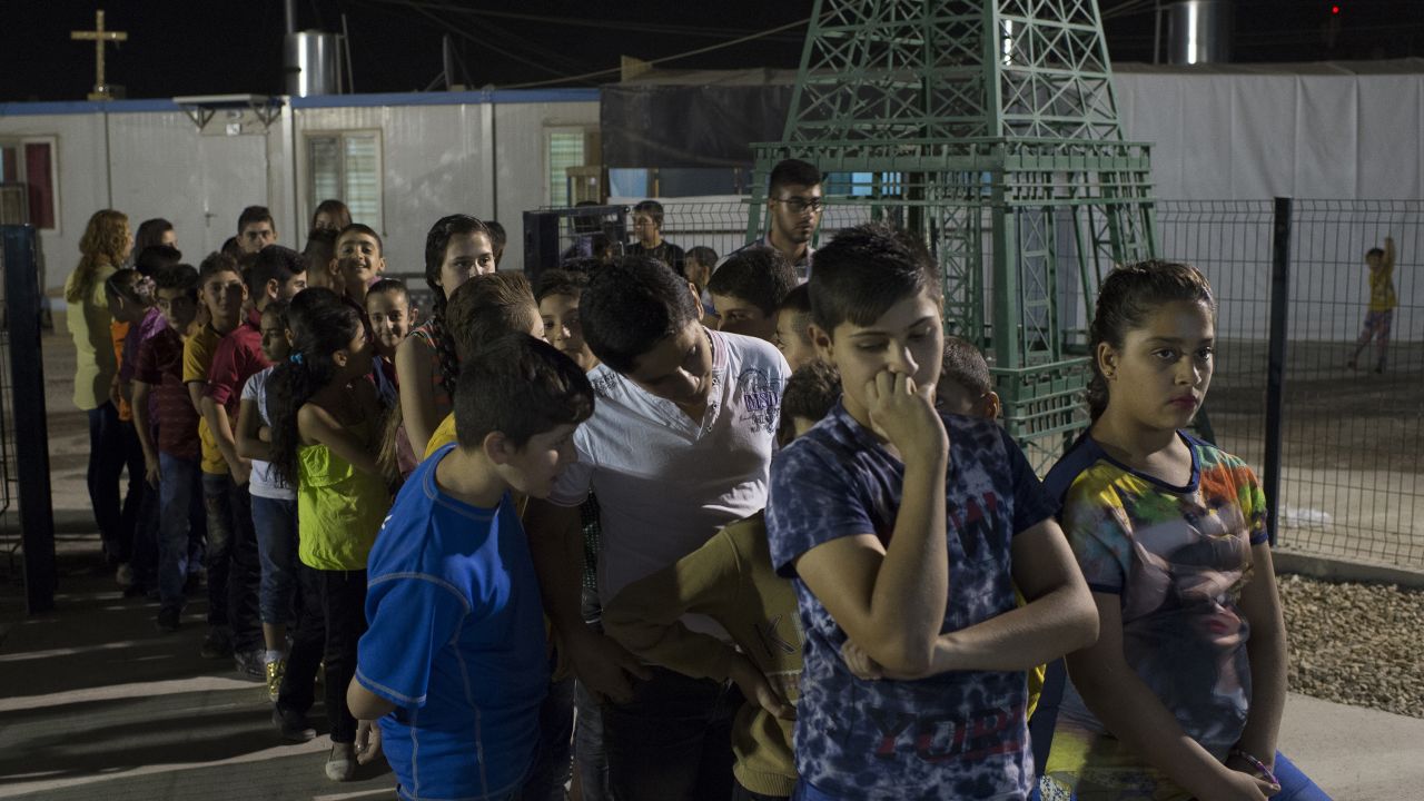 Young Iraqis wait for communion outside a church in<strong> </strong>Irbil's Ashti camp.