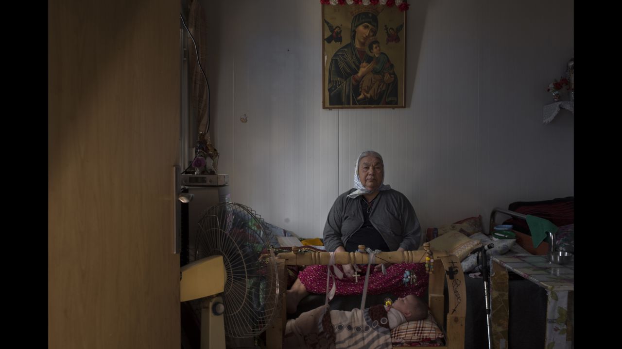 An elderly woman keeps watch over her great-granddaughter at Ashti. She and her family fled Qaraqosh, Iraq's largest Christian city, when ISIS fighters took it over in August 2014.