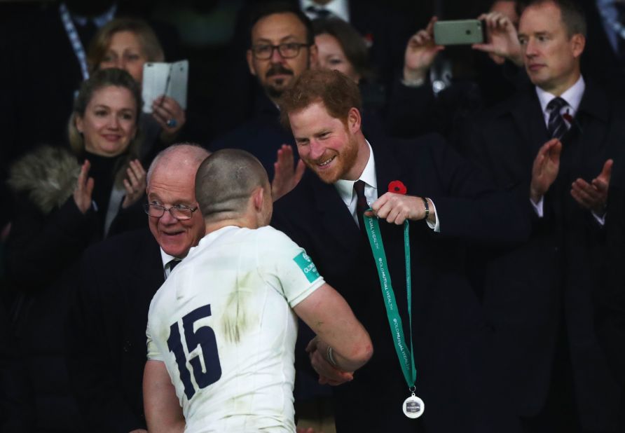 Prince Harry presents a winner's medal to Mike Brown of England.