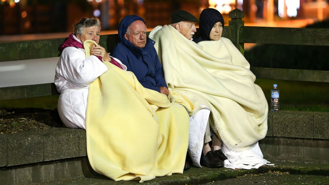 Guests at the Amora Hotel in Wellington gather in a carpark after fleeing their rooms.