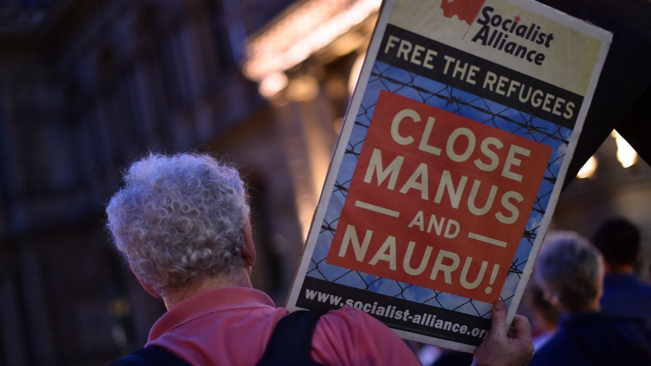 A protester holds a sign calling for the closure of offshore detention camps. 