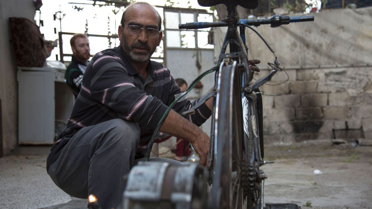 Syrian Abu Rahmo, a 48-year-old mechanic, welds a dynamo -- the small generator used to charge car batteries -- onto the back of an old bicycle in Aleppo's besieged Ansari neighbourhood on October 31, 2016.
Cigarettes stuffed with grape leaves instead of tobacco, gardens on bombed-out rooftops, and batteries powered by rusted bicycles: In Syria's besieged eastern Aleppo, necessity is the mother of invention. More than 250,000 people have been under a government siege in the rebel-held side of the northern city since July, without access to aid, food, fuel, medicine or even cigarettes, sparking severe shortages and exorbitant prices for the few basic goods available, and has forced residents to find innovative ways to cope.
 / AFP / KARAM AL-MASRI        (Photo credit should read KARAM AL-MASRI/AFP/Getty Images)
