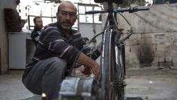 Syrian Abu Rahmo, a 48-year-old mechanic, welds a dynamo -- the small generator used to charge car batteries -- onto the back of an old bicycle in Aleppo's besieged Ansari neighbourhood on October 31, 2016.Cigarettes stuffed with grape leaves instead of tobacco, gardens on bombed-out rooftops, and batteries powered by rusted bicycles: In Syria's besieged eastern Aleppo, necessity is the mother of invention. More than 250,000 people have been under a government siege in the rebel-held side of the northern city since July, without access to aid, food, fuel, medicine or even cigarettes, sparking severe shortages and exorbitant prices for the few basic goods available, and has forced residents to find innovative ways to cope. / AFP / KARAM AL-MASRI        (Photo credit should read KARAM AL-MASRI/AFP/Getty Images)