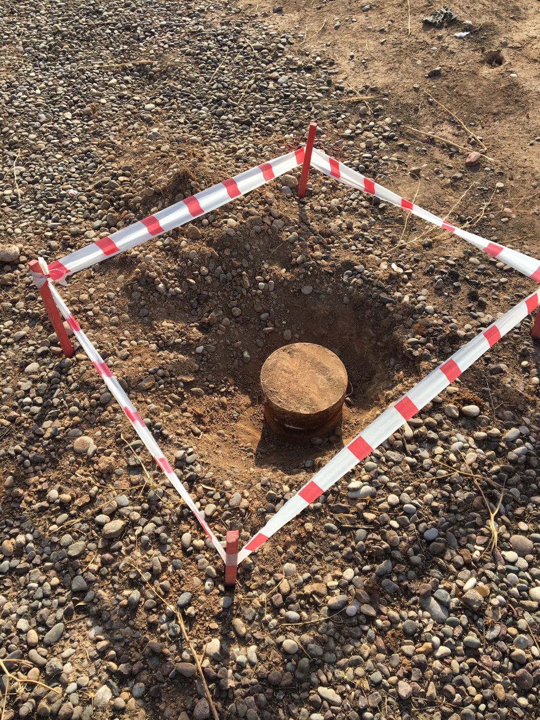 An unexploded mine is sectioned off by the MAG.
