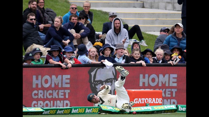 Australian cricket player David Warner crashes over the boundary rope while fielding a ball against South Africa in Hobart, Australia, on Monday, November 14.