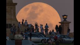 FREMANTLE, AUSTRALIA - NOVEMBER 14: Crowds look on as the super moon rises behind the Fremantle War Memorial at Monument Hill on November 14, 2016 in Fremantle, Australia. A super moon occurs when a full moon passes closes to earth than usual, with the November 14th moon expected to be closer than it has been in over 70 years.  (Photo by Paul Kane/Getty Images)
