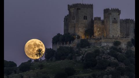 Ay, 13 Kasım Pazar günü İspanya'nın Cordoba kentindeki Almodovar kalesinin arkasında yükseliyor.