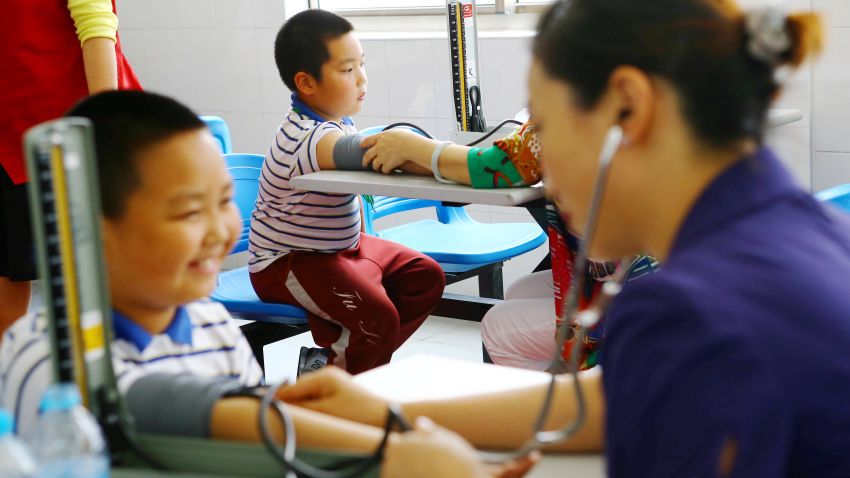 Chinese workers measure blood pressures of obese young students during a physical examination at a school in Shanghai, China, 27 May 2014.