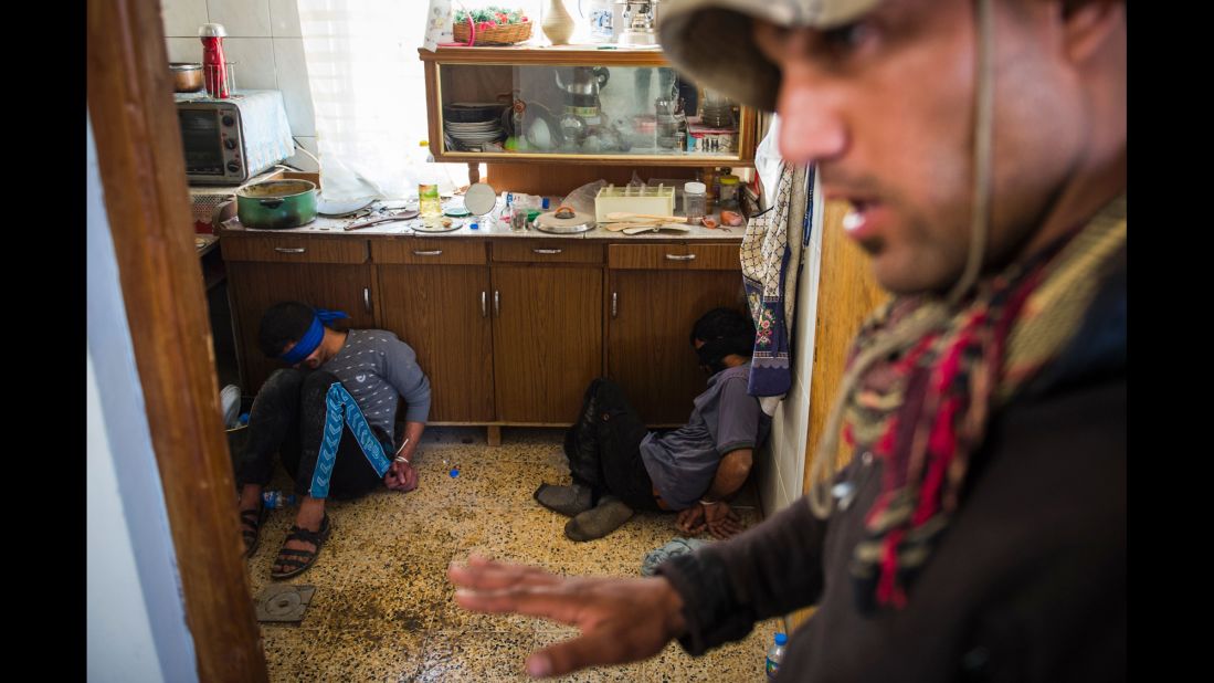 <strong>November 11:</strong> A member of Iraq's special forces guards two suspected ISIS fighters found hiding in a house in Mosul, Iraq. An Iraqi-led offensive was launched in October <a href="http://www.cnn.com/2016/10/17/world/gallery/mosul/index.html" target="_blank">to reclaim Mosul,</a> Iraq's second-largest city and the last major stronghold for ISIS in the country.