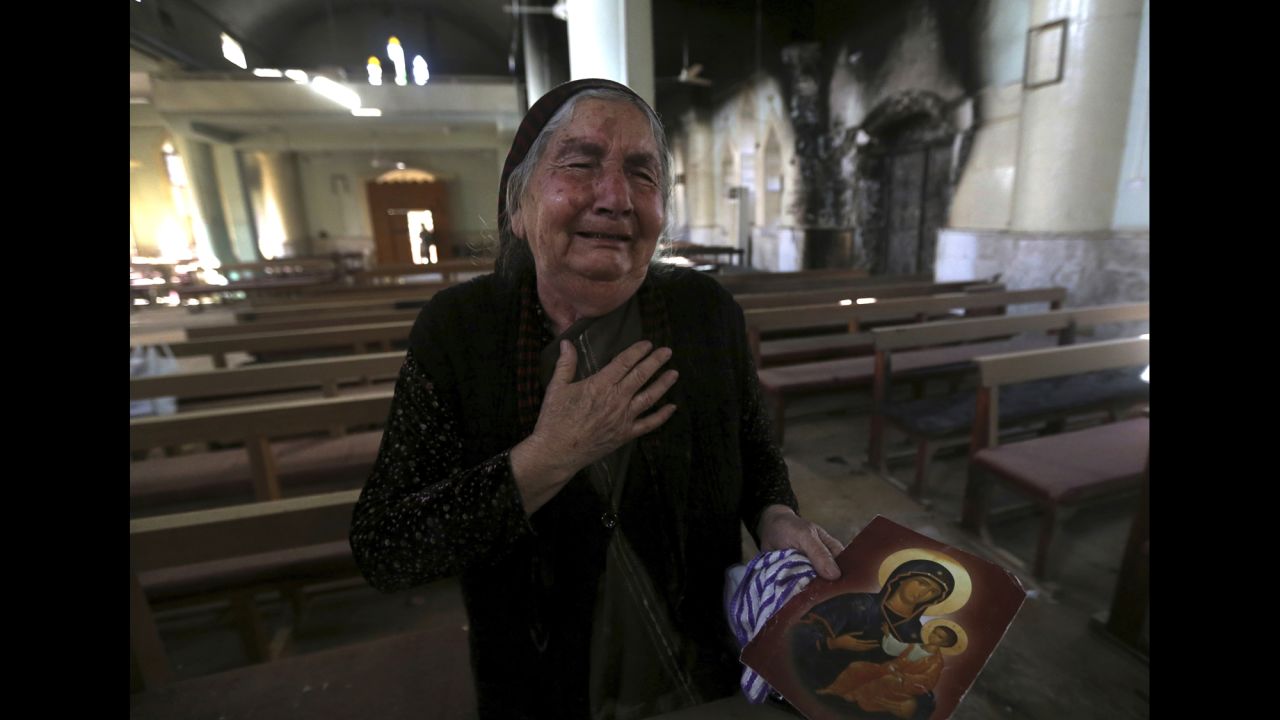 A woman cries Sunday, November 13, after seeing the St. Addai church that was damaged by ISIS fighters during their occupation of the Keramlis village.