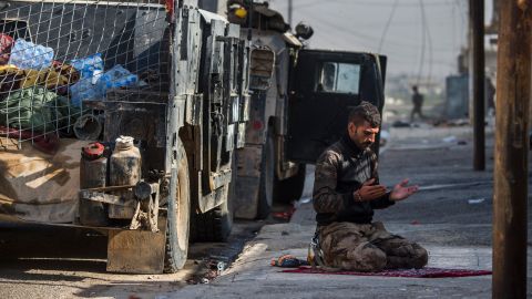 An Iraqi special forces soldier prays next to a Humvee before troops pushed toward Mosul's Karkukli neighborhood on November 13.