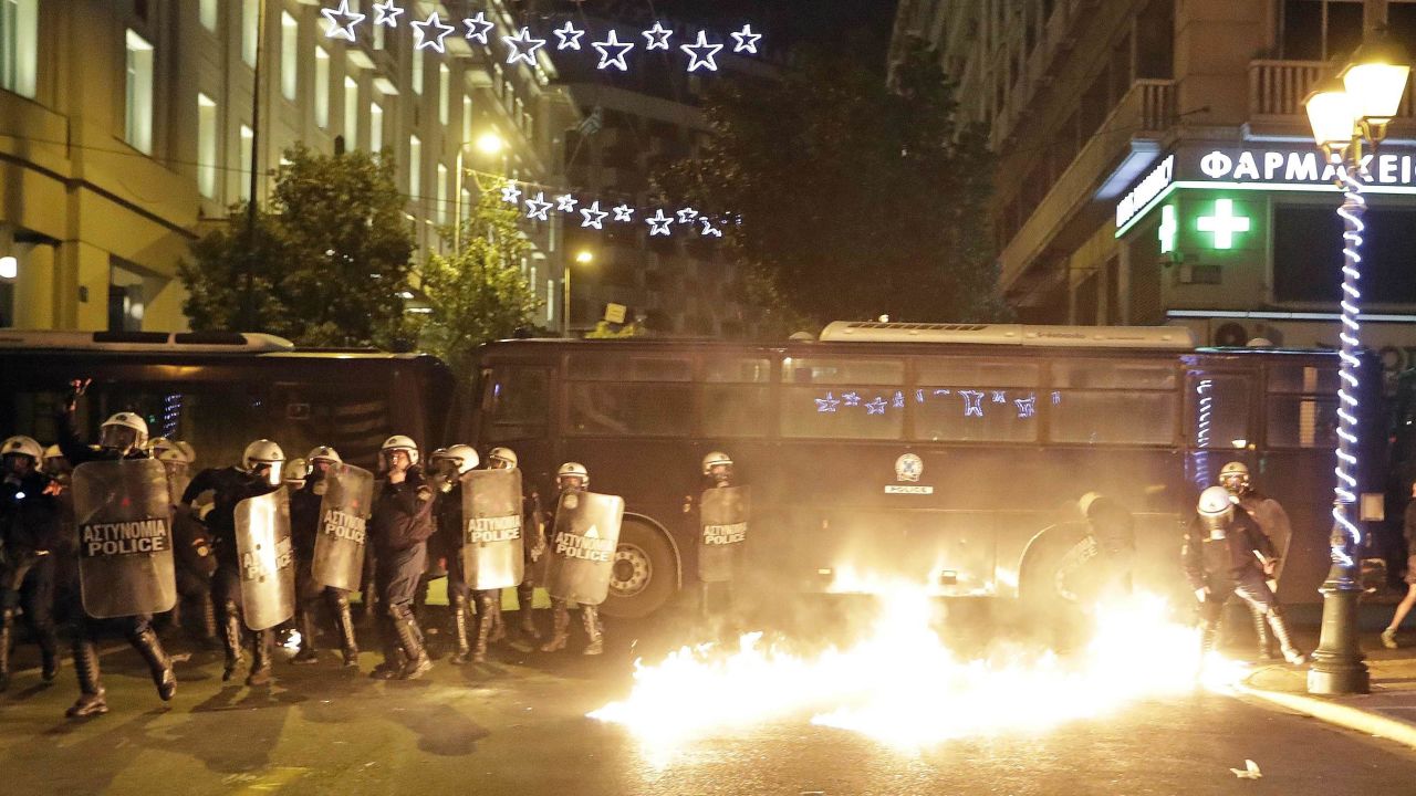 Police look at flames from a fire bomb thrown by demonstrators Tuesday.