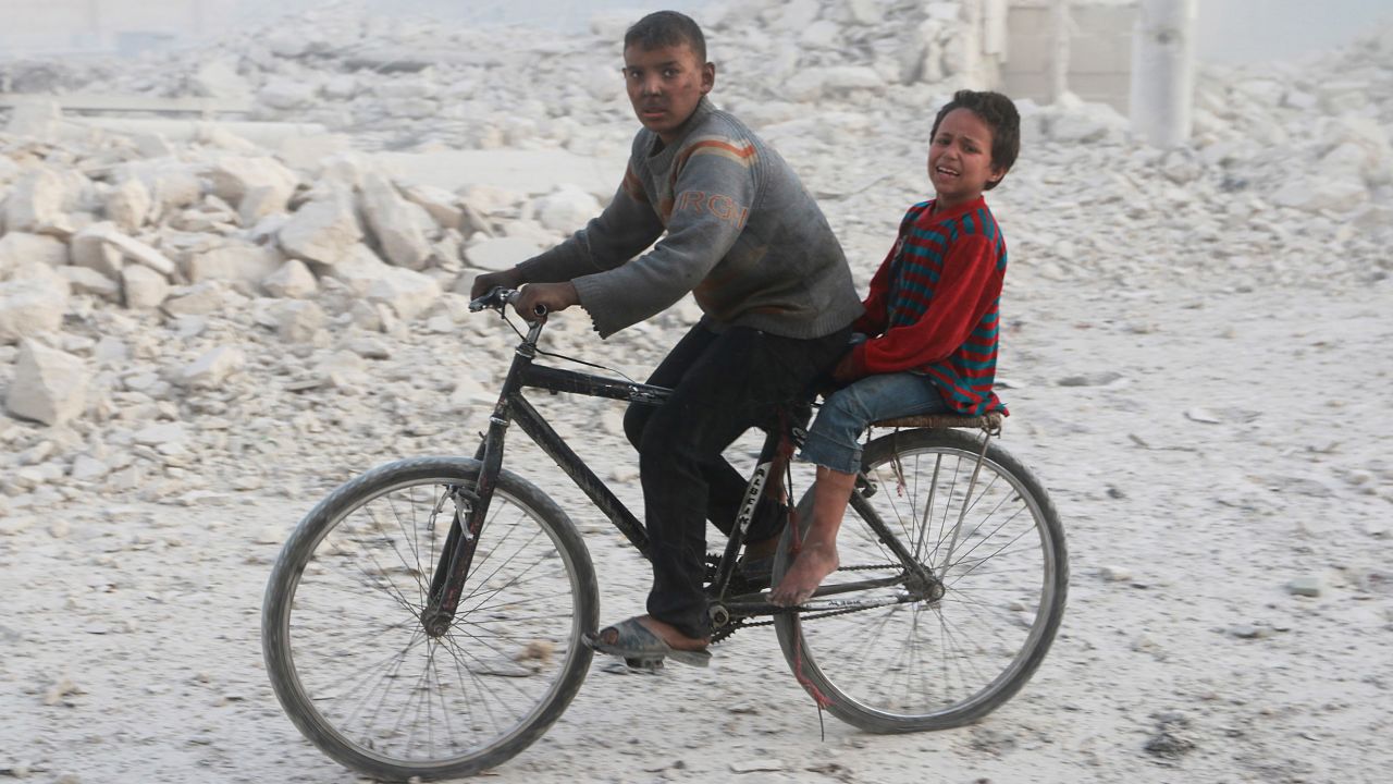 Children flee after airstrikes hit their neighborhood in eastern Aleppo on Tuesday. 