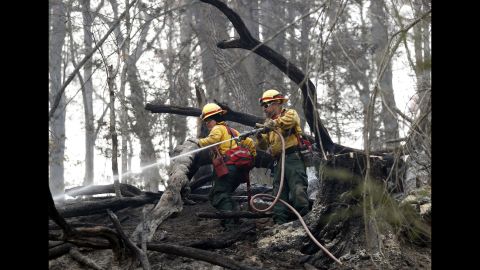 Firefighters Valarie Lopez and Mark Tabaez work to cool hot spots in Clayton on November 15. A number of the fires are being investigated as suspected arson, but weather conditions are also responsible for the fires.